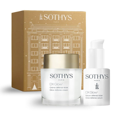 Coffret cosmétique Prévente - Coffret défense éclat, boîte dorée à motif architectural avec crème blanche et sérum en flacon pompe.