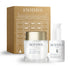 Coffret cosmétique Prévente - Coffret défense éclat, boîte dorée à motif architectural avec crème blanche et sérum en flacon pompe.