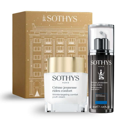 Coffret focus rides Sothys avec crème jeunesse blanche et dorée et sérum noir à pompe, présentés dans un coffret doré illustré.