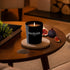 Black SOTHYS bougie parfumée candle with cumin and fig scent on wooden table with figs and cumin seeds.